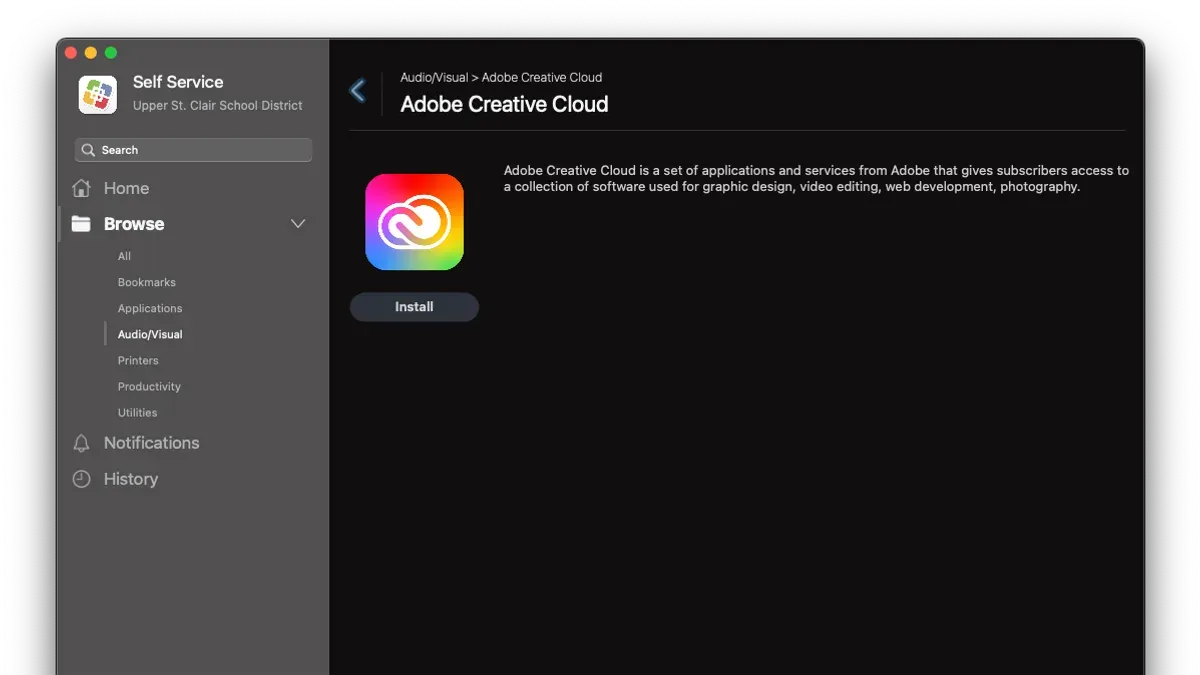 Person installing Adobe Creative Cloud on MacBook showing installation screen