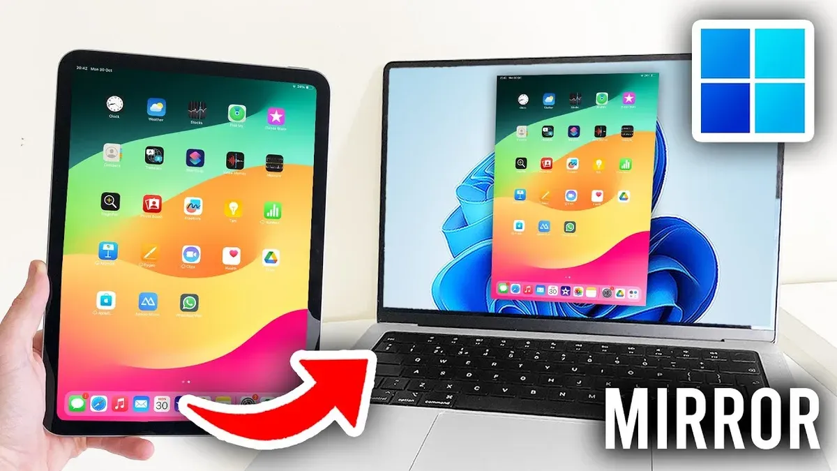 Person switching from iPads to Windows laptops working with both devices on desk