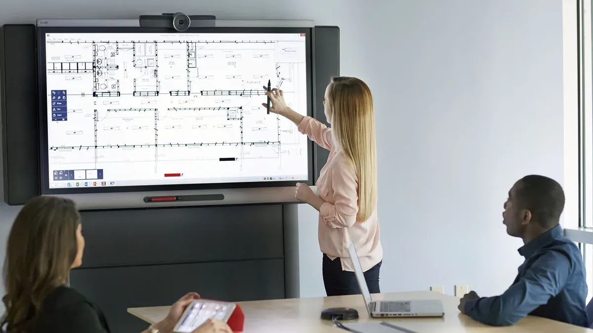 Teacher demonstrating switching from SMART Board to interactive flat panel in classroom