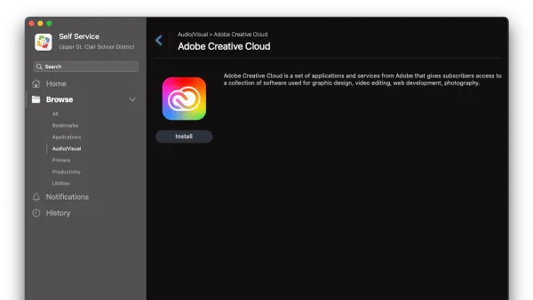 Person installing Adobe Creative Cloud on MacBook showing installation screen