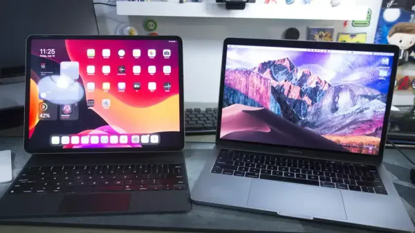 Person switching from iPads to MacBooks using both devices at a desk